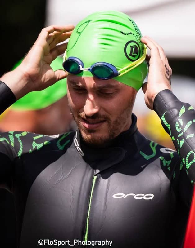 Photo d'un nageur en combinaison et bonnet se concentrant avant l'épreuve