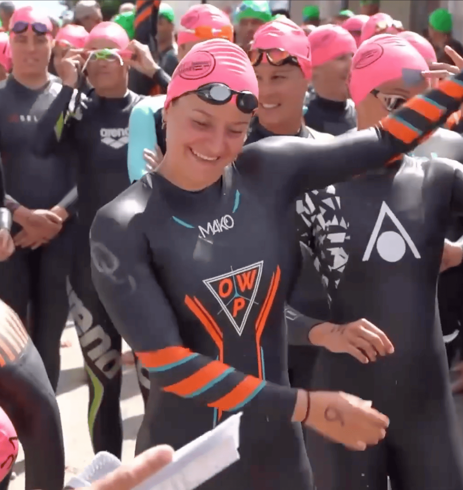 Photos d'un groupe de nageurs prêts au départ. Au premier plan, une nageuse entrain de s'étirer.