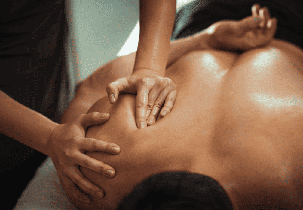 Photo d'un Kinésithérapeute massant le dos d'un patient.